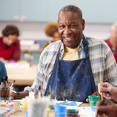 elderly resident smiling while painting 