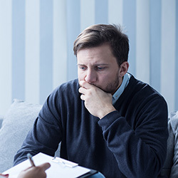 man looking thoughtfully at a piece of paper