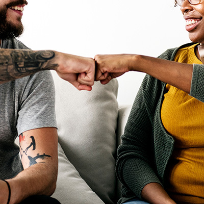 two people smiling and fist bumping