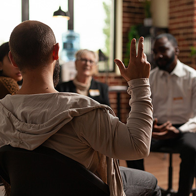 several people sitting in a therapy circle and talking